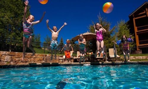Kids jumping into swimming pool at Snowmass Club